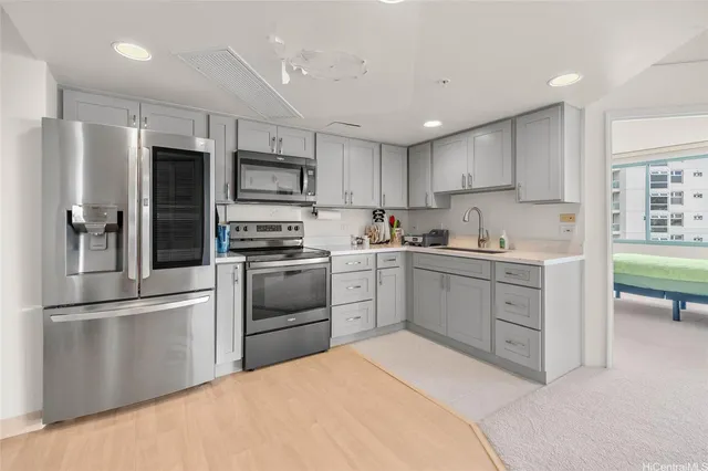 a kitchen with white cabinets and stainless steel appliances