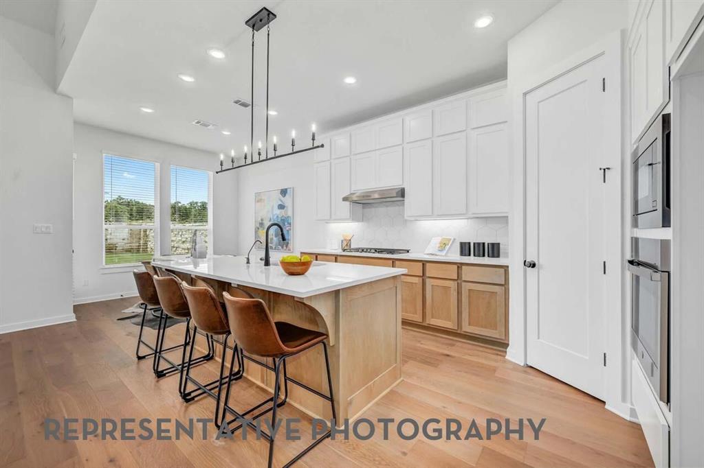 8715 Wildberry Road Oak Point, TX 75068 - Photo 2 of 23 a kitchen with stainless steel appliances granite countertop a refrigerator a sink dishwasher a stove and white cabinets with wooden floor