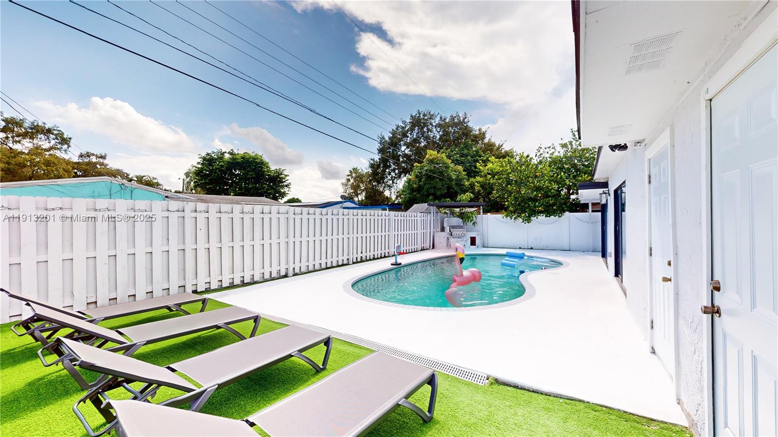 a table and chairs sitting in a backyard with swimming pool