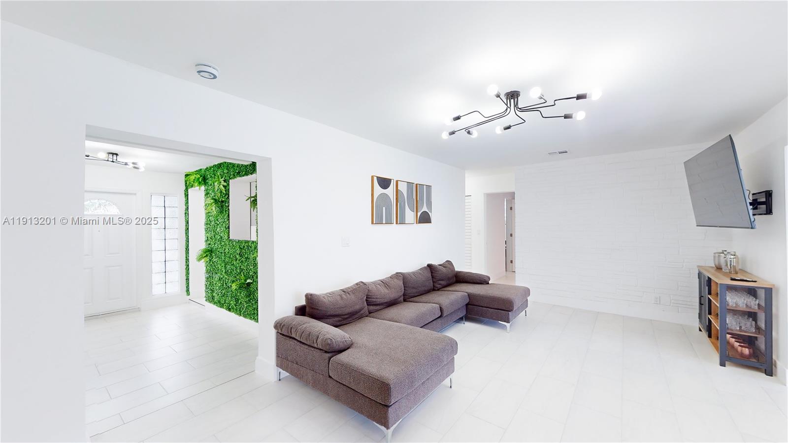 6630 Cody Street Hollywood, FL 33024 - Photo 8 of 45 a living room with furniture a flat screen tv and a window