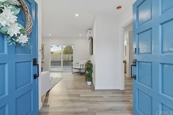 a view of a hallway with wooden floor and a chandelier