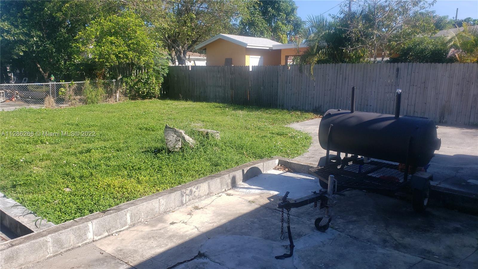 559 Dogwood Road West Palm Beach, FL 33409 - Photo 7 of 7 a view of a chair and table in backyard with wooden fence