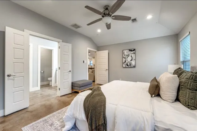 a bedroom with a large bed and a chandelier