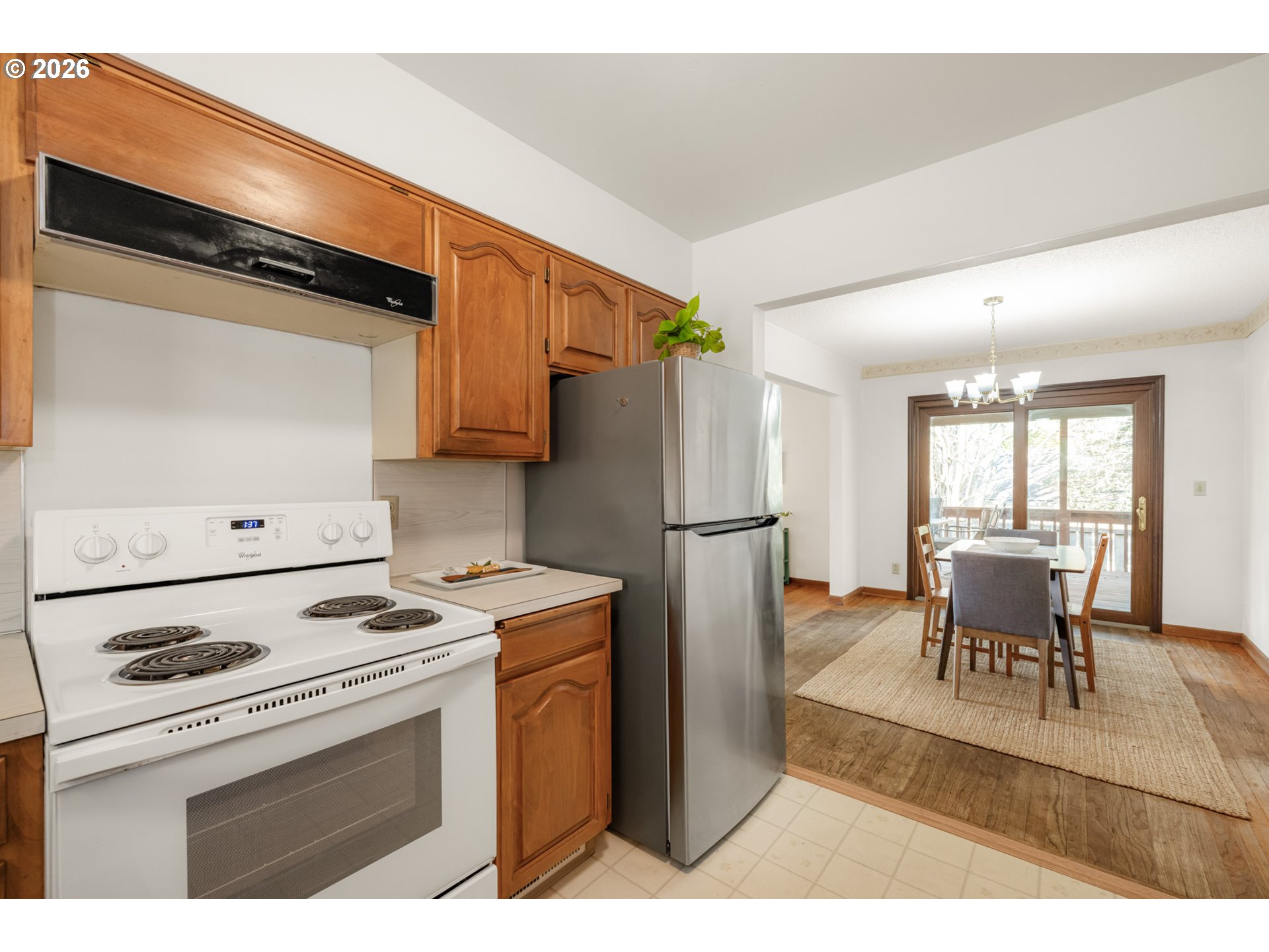 9025 Southwest Avery Street Tualatin, OR 97062 - Photo 12 of 35 a kitchen with a refrigerator a stove a dining table and chairs