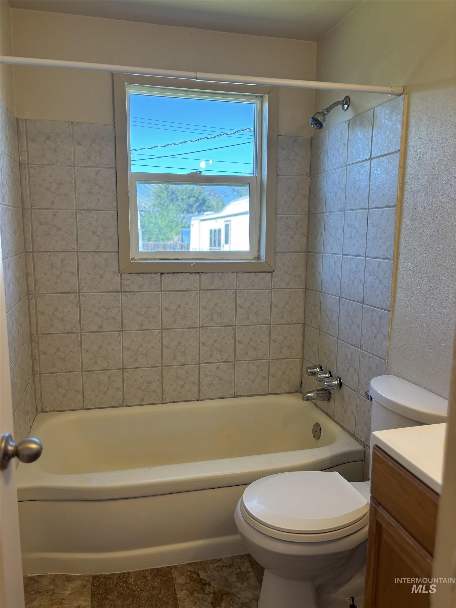 5116 West Morris Hill Road Boise, ID 83706 - Photo 11 of 19 Bathroom featuring a tiled shower surround, integrated bathtub, and a window for natural light