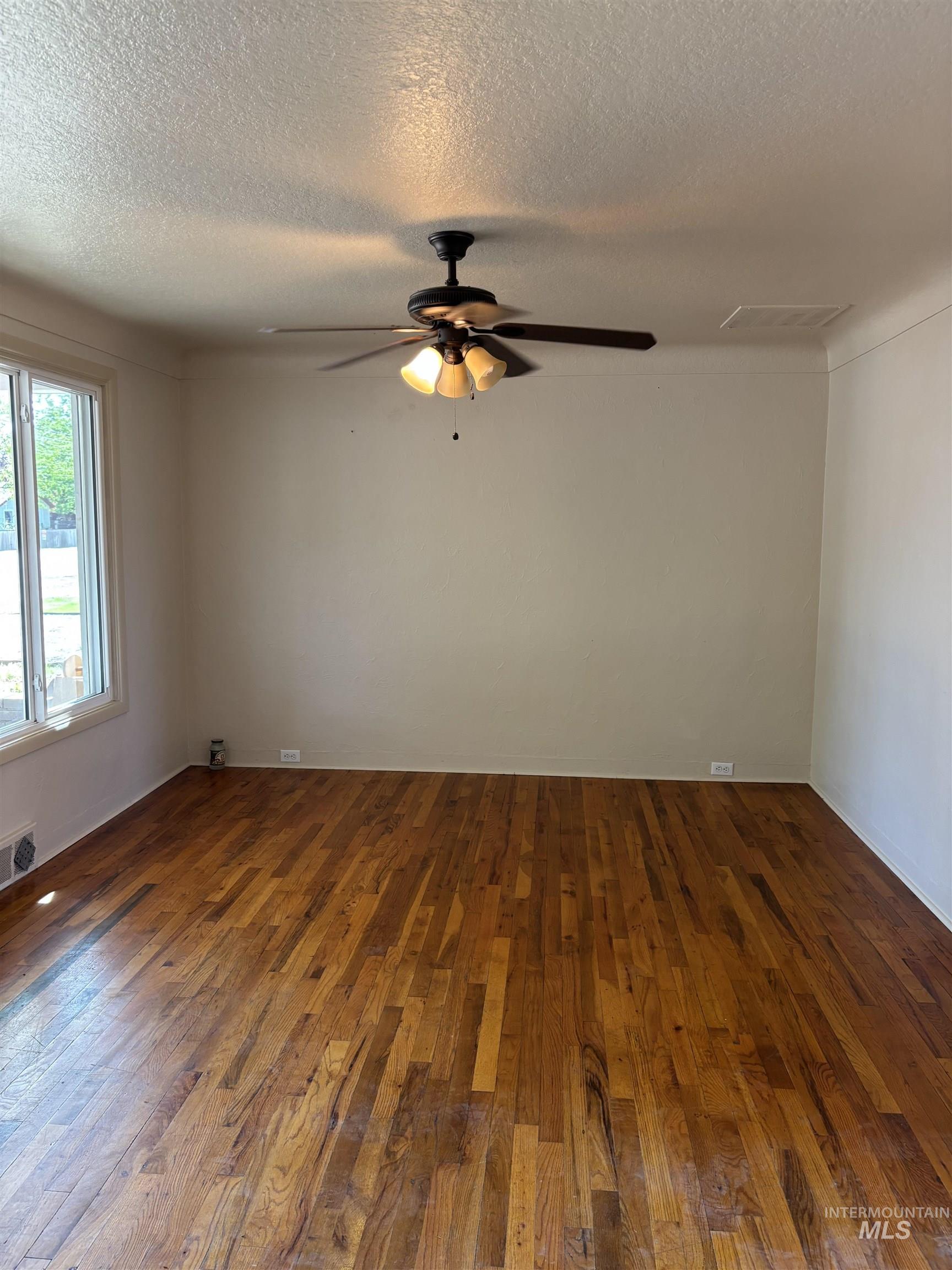 5116 West Morris Hill Road Boise, ID 83706 - Photo 4 of 19 Spacious interior featuring wood-finish flooring, a ceiling fan with integrated lighting, and multiple windows providing natural light