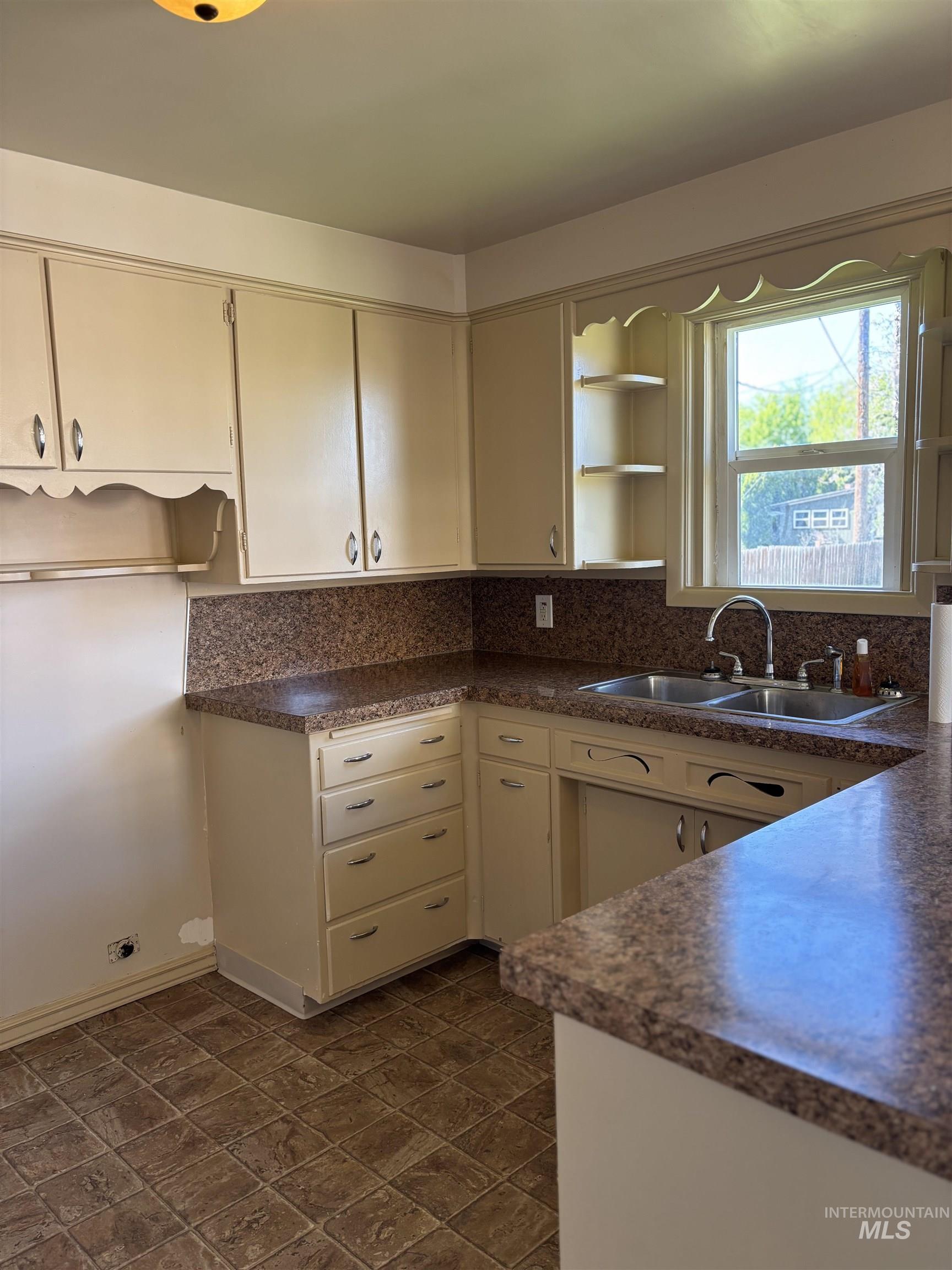 5116 West Morris Hill Road Boise, ID 83706 - Photo 5 of 19 Kitchen featuring cream-colored cabinetry, patterned countertops, and a double basin sink