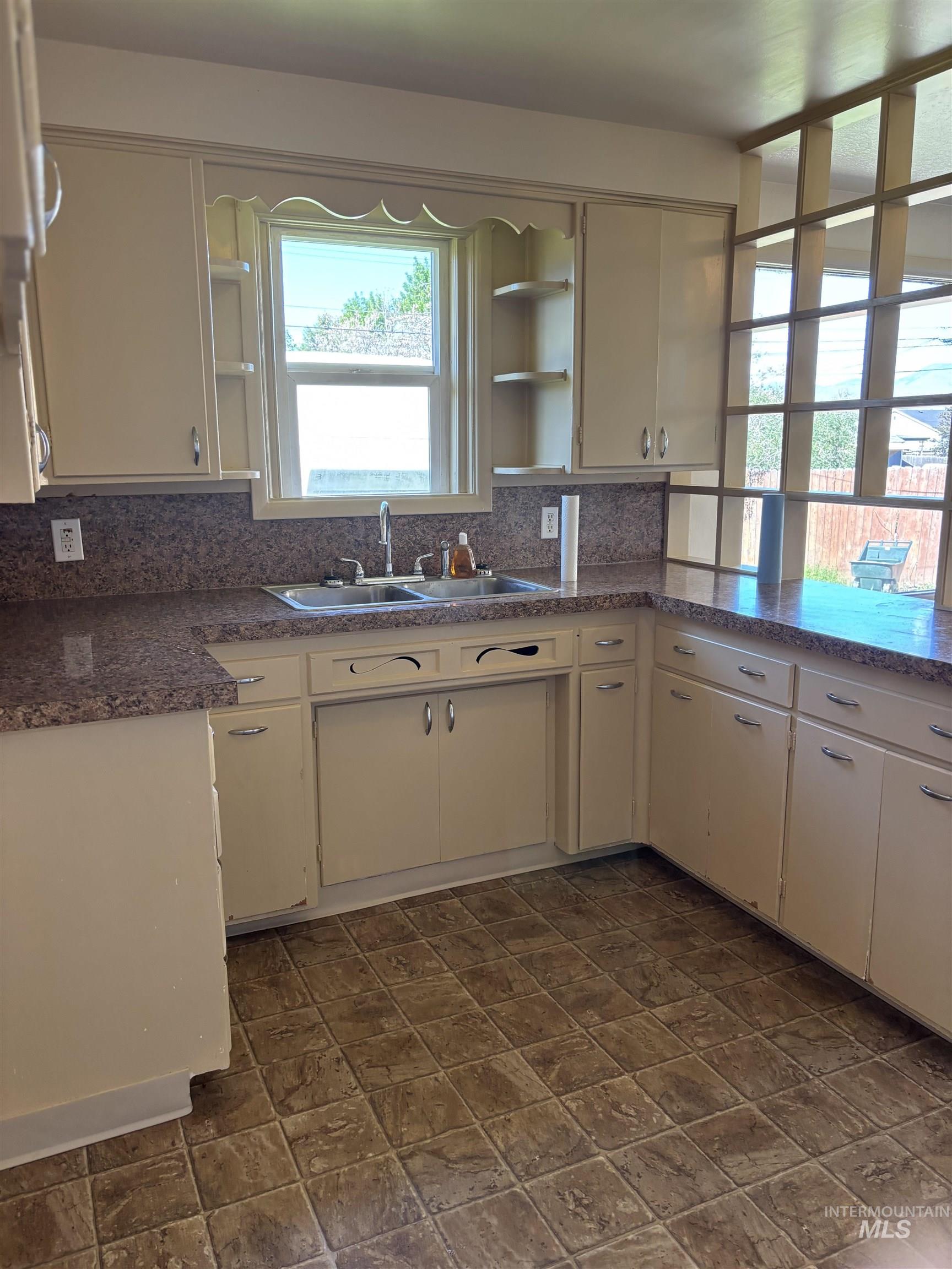 5116 West Morris Hill Road Boise, ID 83706 - Photo 6 of 19 Kitchen featuring dual basin stainless steel sink, patterned laminate countertops, and white cabinetry