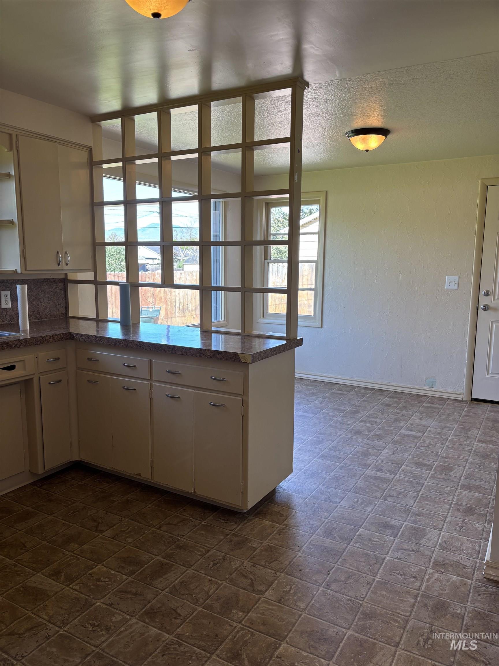 5116 West Morris Hill Road Boise, ID 83706 - Photo 7 of 19 Kitchen featuring tile-pattern flooring and light-toned cabinetry