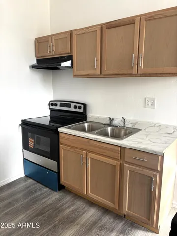 a kitchen with granite countertop a stove a sink and dishwasher