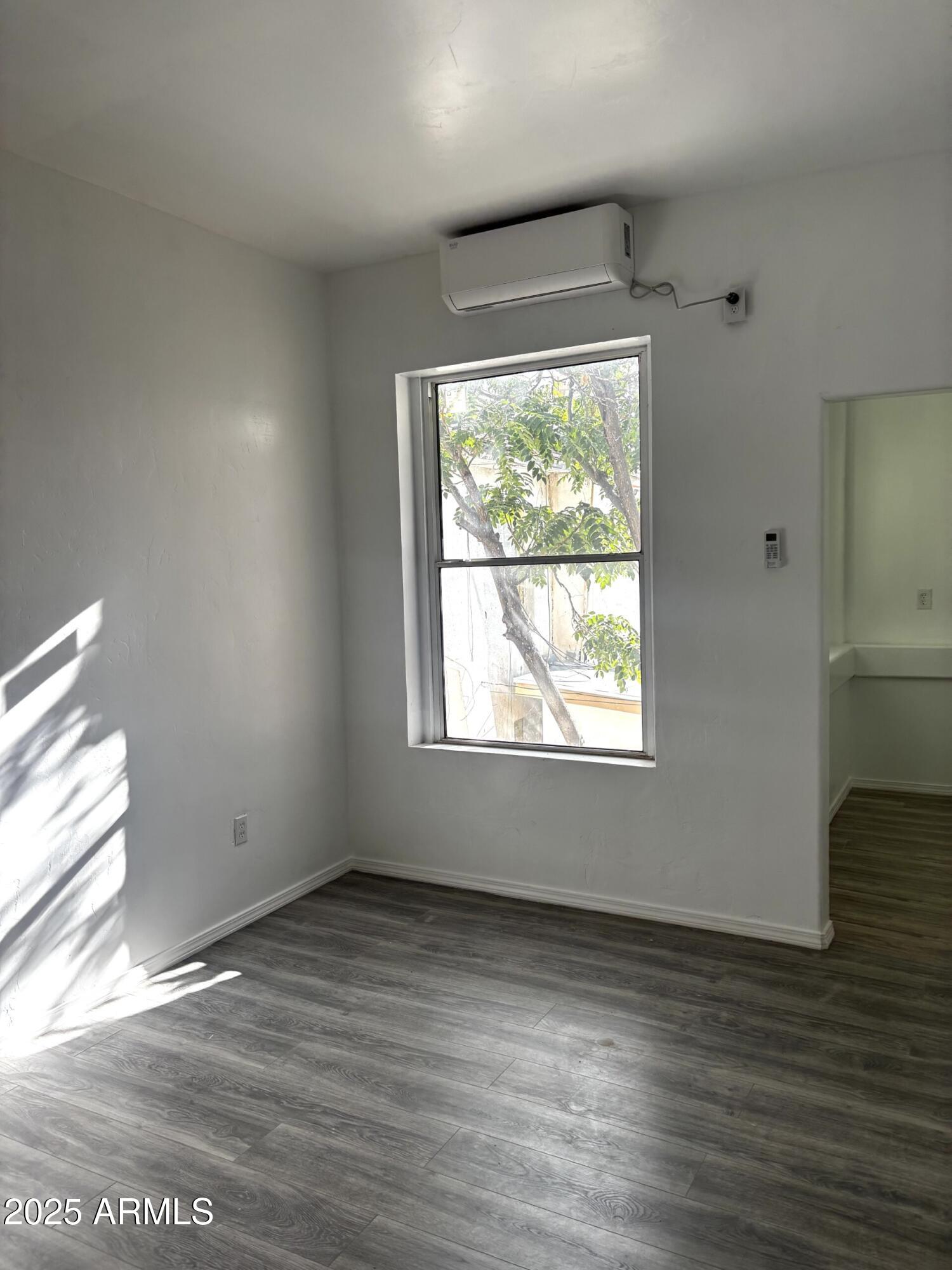 633 East 9th Street, Unit 14 Douglas, AZ 85607 - Photo 2 of 7 a view of an empty room with wooden floor and a window