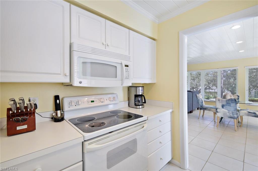 286 4th Street South, Unit 203 Naples, FL 34102 - Photo 8 of 25 a kitchen with cabinets appliances and a counter top space