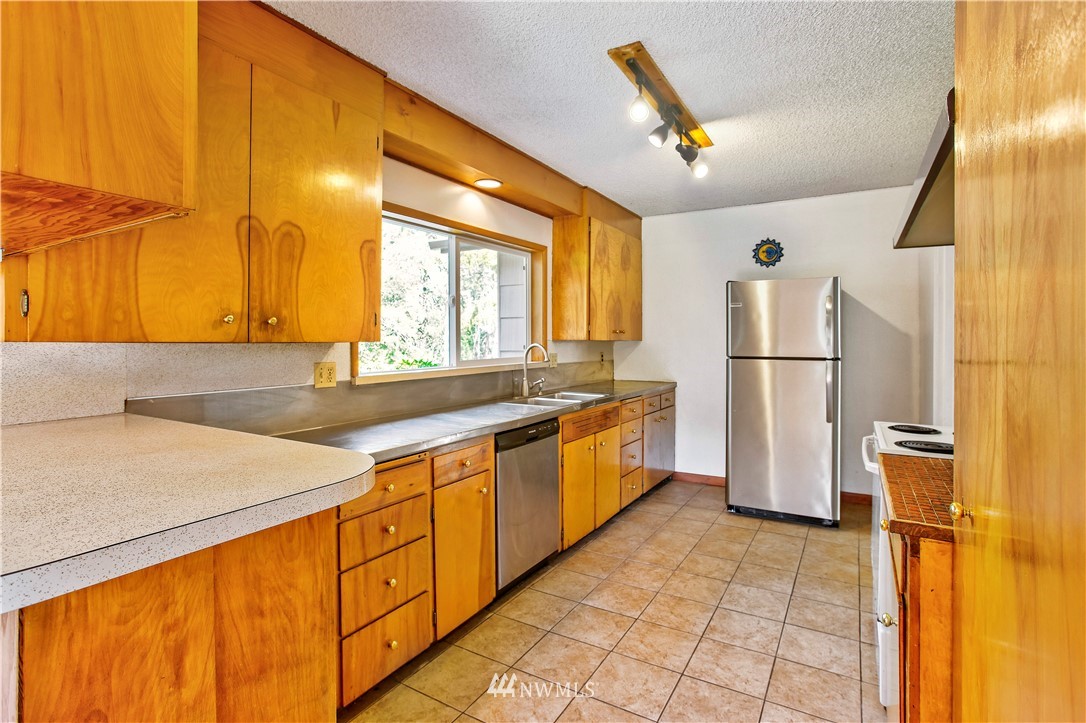 16919 112th Place Northeast Bothell, WA 98011 - Photo 11 of 40 a kitchen with stainless steel appliances granite countertop a sink and cabinets