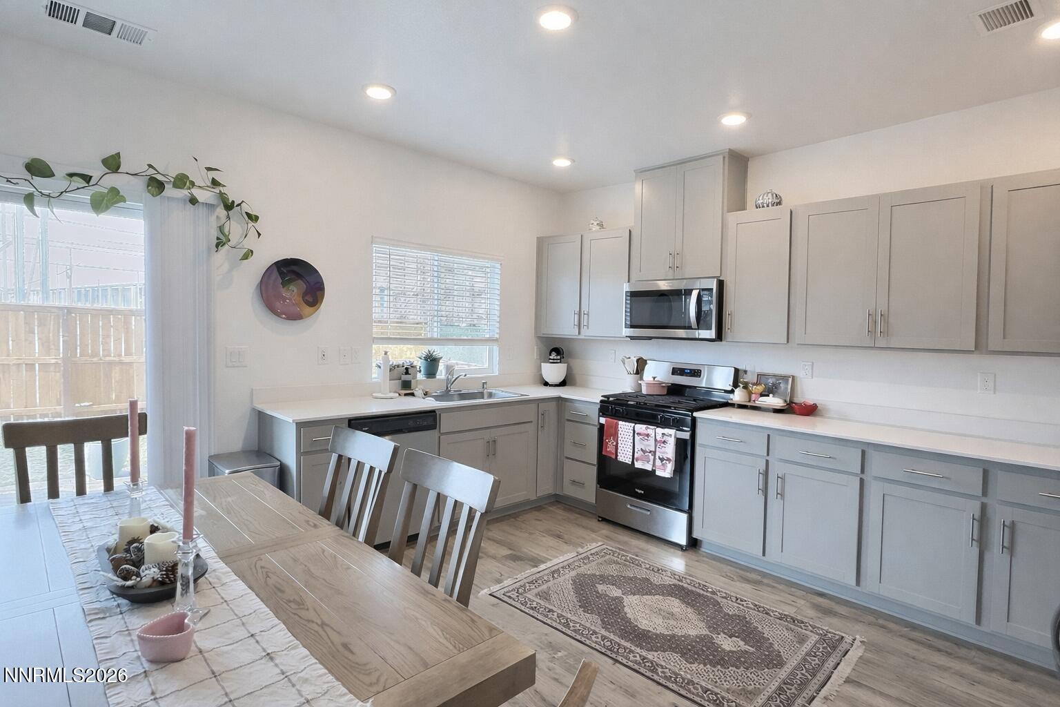 641 Pleasant Vista Drive Reno, NV 89506 - Photo 11 of 30 a kitchen with stainless steel appliances granite countertop a stove top oven a sink dishwasher and white cabinets with wooden floor