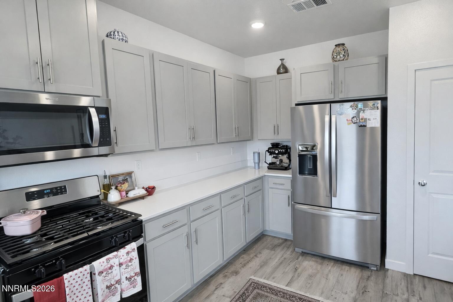 641 Pleasant Vista Drive Reno, NV 89506 - Photo 12 of 30 a kitchen with stainless steel appliances a refrigerator a stove and white cabinets