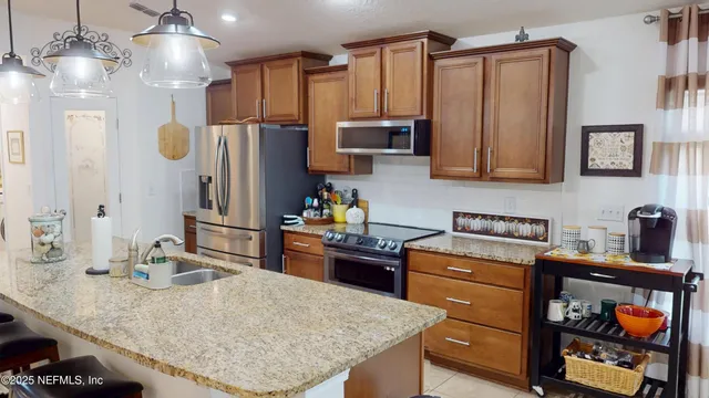 a kitchen with stainless steel appliances granite countertop a sink refrigerator and microwave