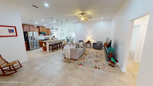 a living room with furniture a chandelier and kitchen view