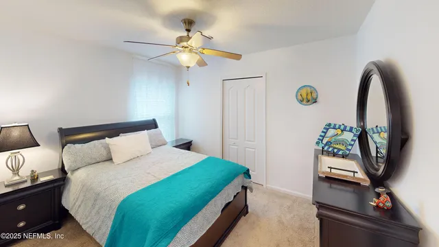 a bedroom with a bed and a flat tv screen on dresser