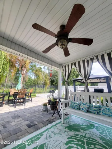 a living room with patio furniture and a floor to ceiling window