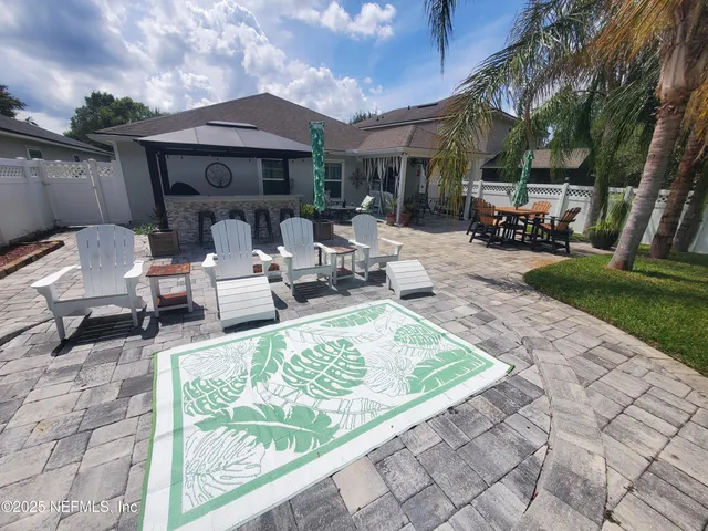 a view of a patio with dining table and chairs with a fire pit and a yard