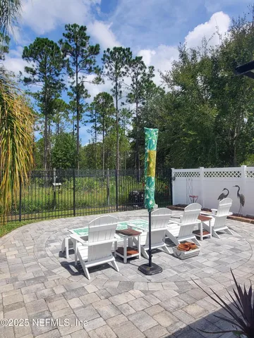 a view of a patio with a bench and some trees