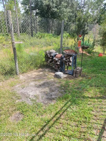 a view of backyard with table and chairs and potted plants