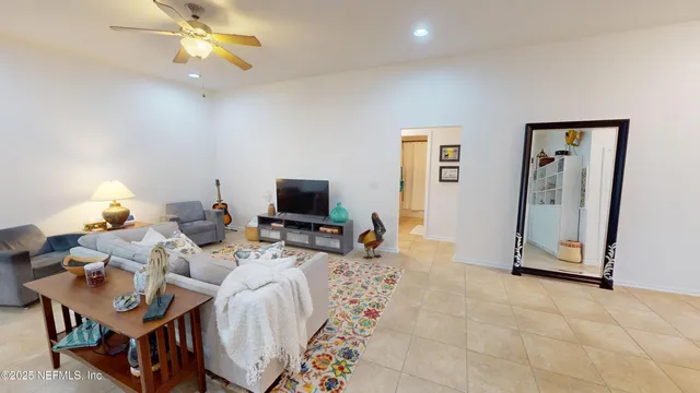 a living room with furniture a flat screen tv and a chandelier
