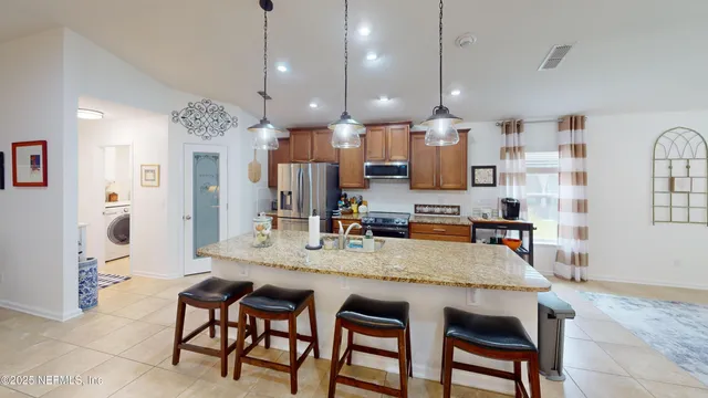 a kitchen with kitchen island a dining table chairs sink and wooden floor