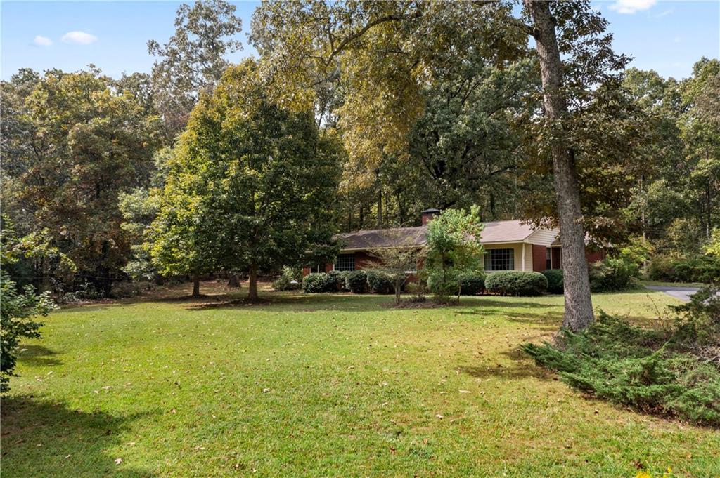 79 Floyd Road Southwest Cartersville, GA 30120 - Photo 4 of 50 a view of a large pool with lawn chairs under an umbrella