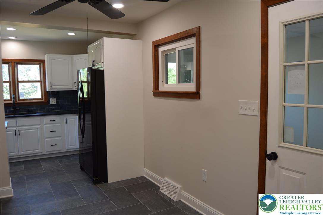930 Morvale Road Easton, PA 18042 - Photo 12 of 36 a kitchen with a refrigerator and white cabinets