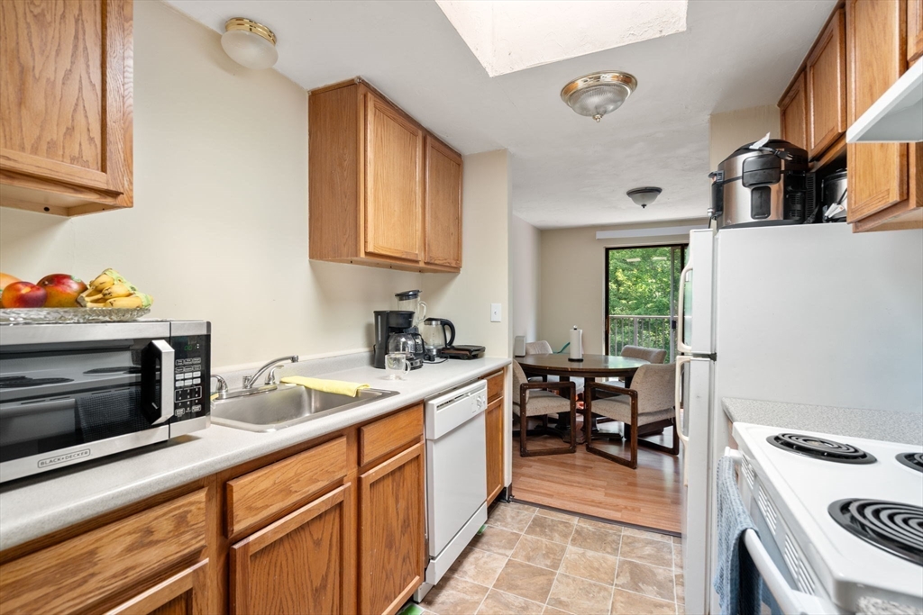 688 Boston Post Road East, Unit 304 Marlborough, MA 01752 - Photo 6 of 20 a kitchen with a sink stove and cabinets