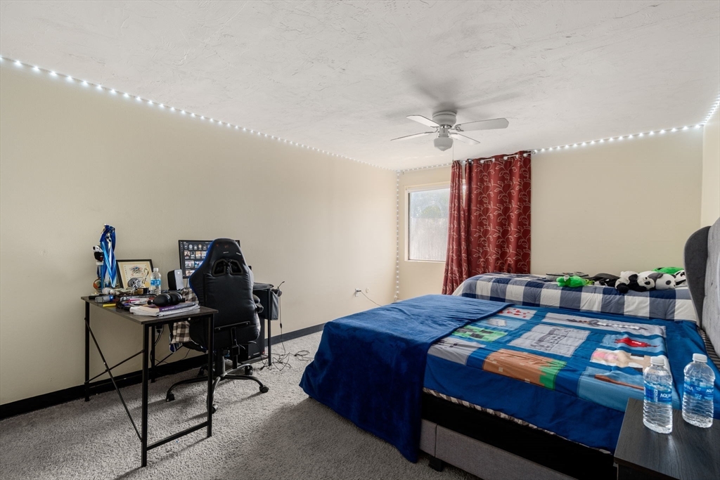 688 Boston Post Road East, Unit 304 Marlborough, MA 01752 - Photo 8 of 20 a bedroom with a bed table chair and a window