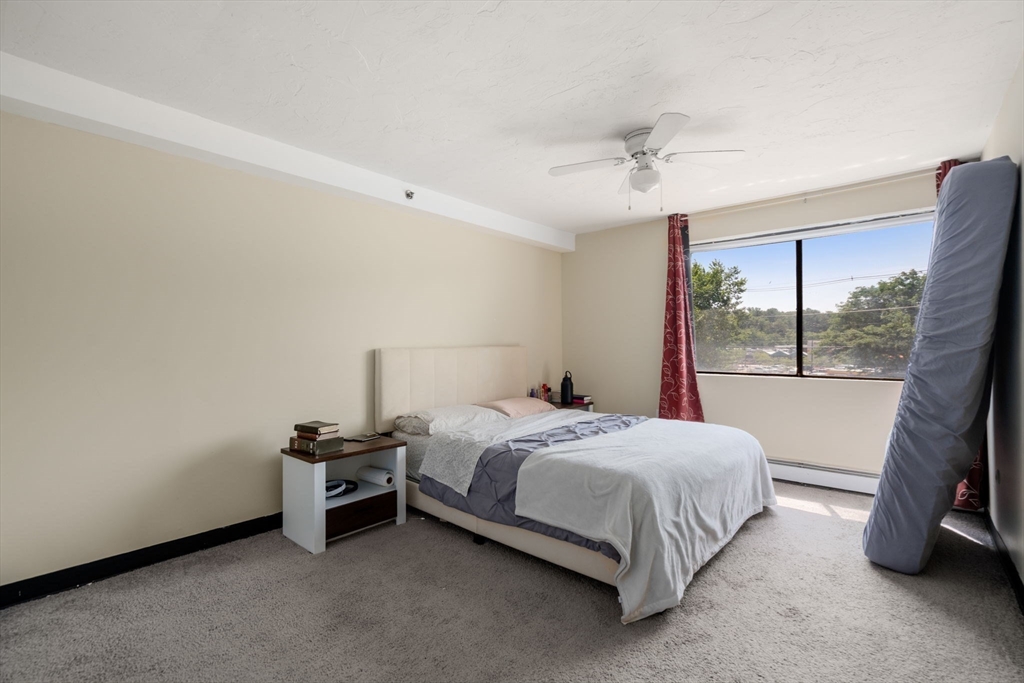 688 Boston Post Road East, Unit 304 Marlborough, MA 01752 - Photo 9 of 20 a bed sitting in a room next to a window