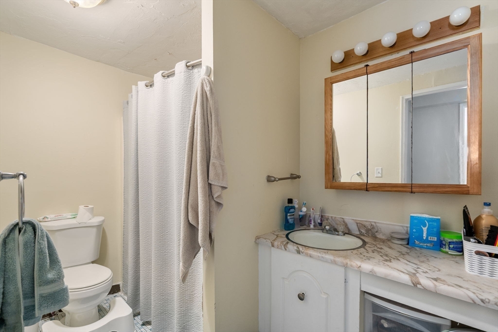 688 Boston Post Road East, Unit 304 Marlborough, MA 01752 - Photo 10 of 20 a bathroom with a granite countertop sink toilet and shower