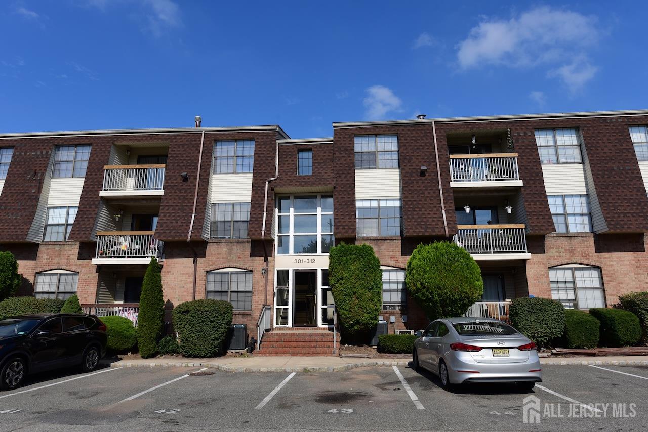 307 Hidden Village Drive Perth Amboy, NJ 08861 - Photo 18 of 18 a car parked in front of a brick house