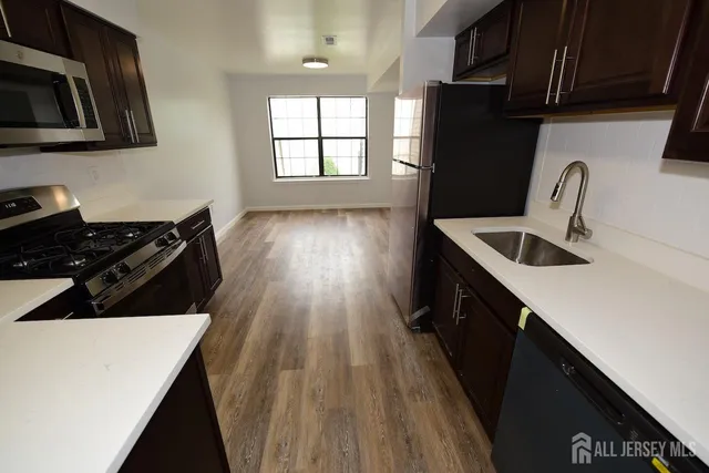 a kitchen with a sink a stove and cabinets