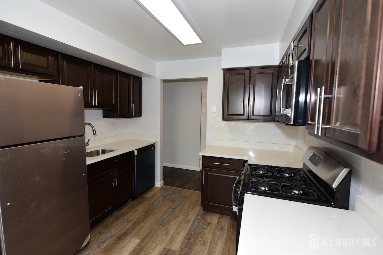 307 Hidden Village Drive Perth Amboy, NJ 08861 - Photo 6 of 18 a kitchen with a refrigerator sink and cabinets