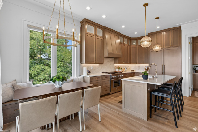 12308 Mariah Circle Draper, UT 84020 - Photo 188 of 293 Guest House Modern kitchen featuring extensive wood-finish cabinetry, a large center island with seating, stainless steel appliances, and light wood-finish flooring