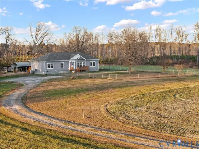a view of pool in front of house with yard and trees
