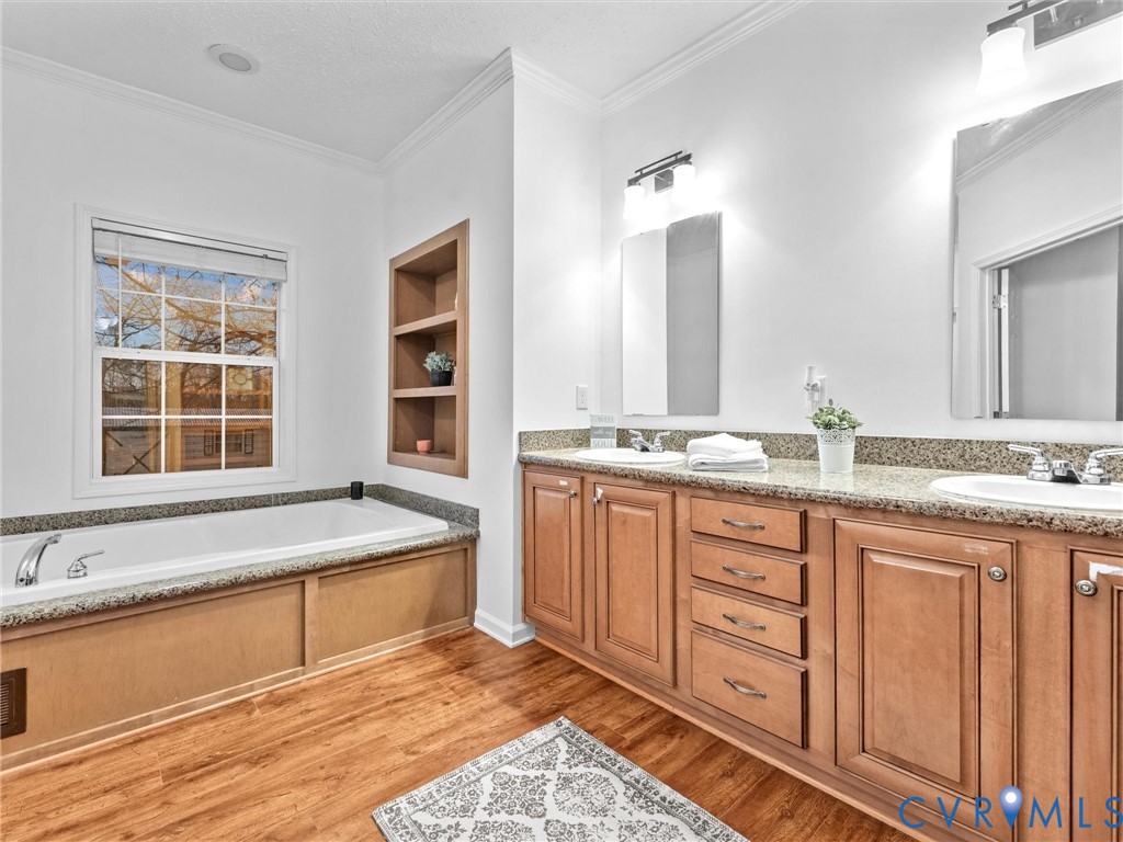 10885 Zilles Road Wilsons, VA 23894 - Photo 32 of 44 a spacious bathroom with a granite countertop double vanity sink a mirror and a bathtub