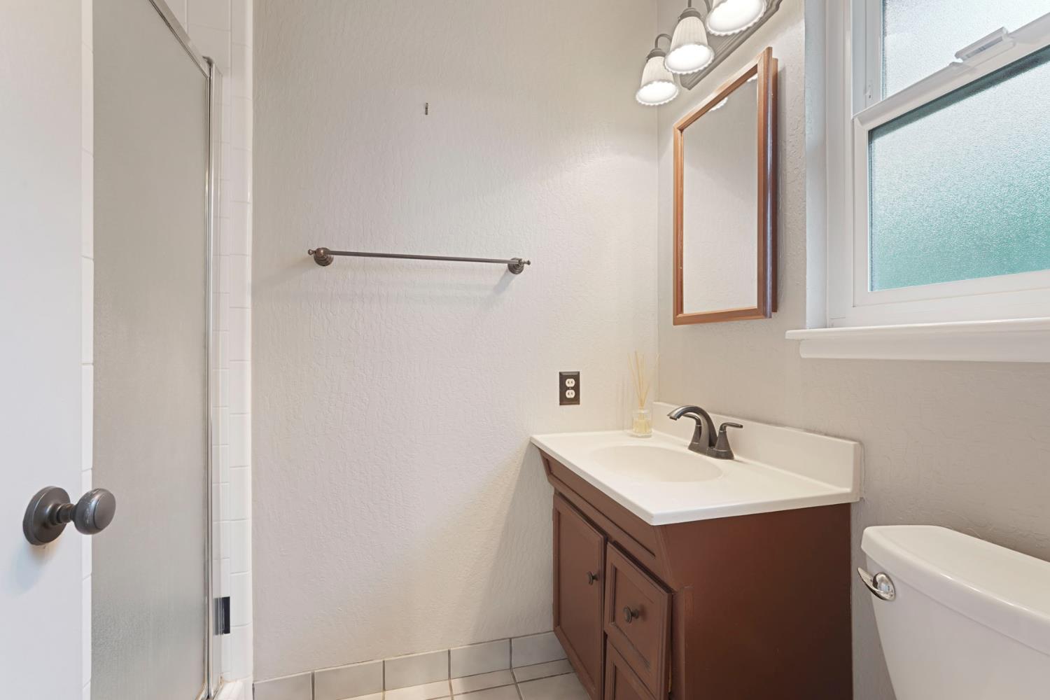 1007 Cardinal Street Lodi, CA 95240 - Photo 22 of 31 a bathroom with a sink and mirror with toilet