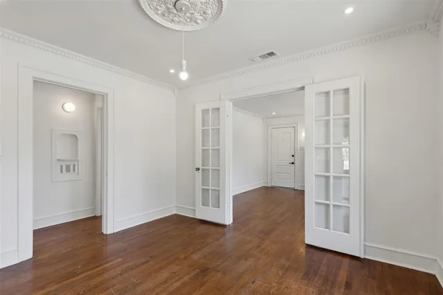 a view of an empty room with wooden floor