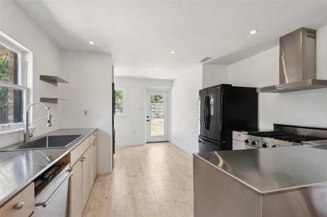 a kitchen with stainless steel appliances granite countertop a sink stove and refrigerator