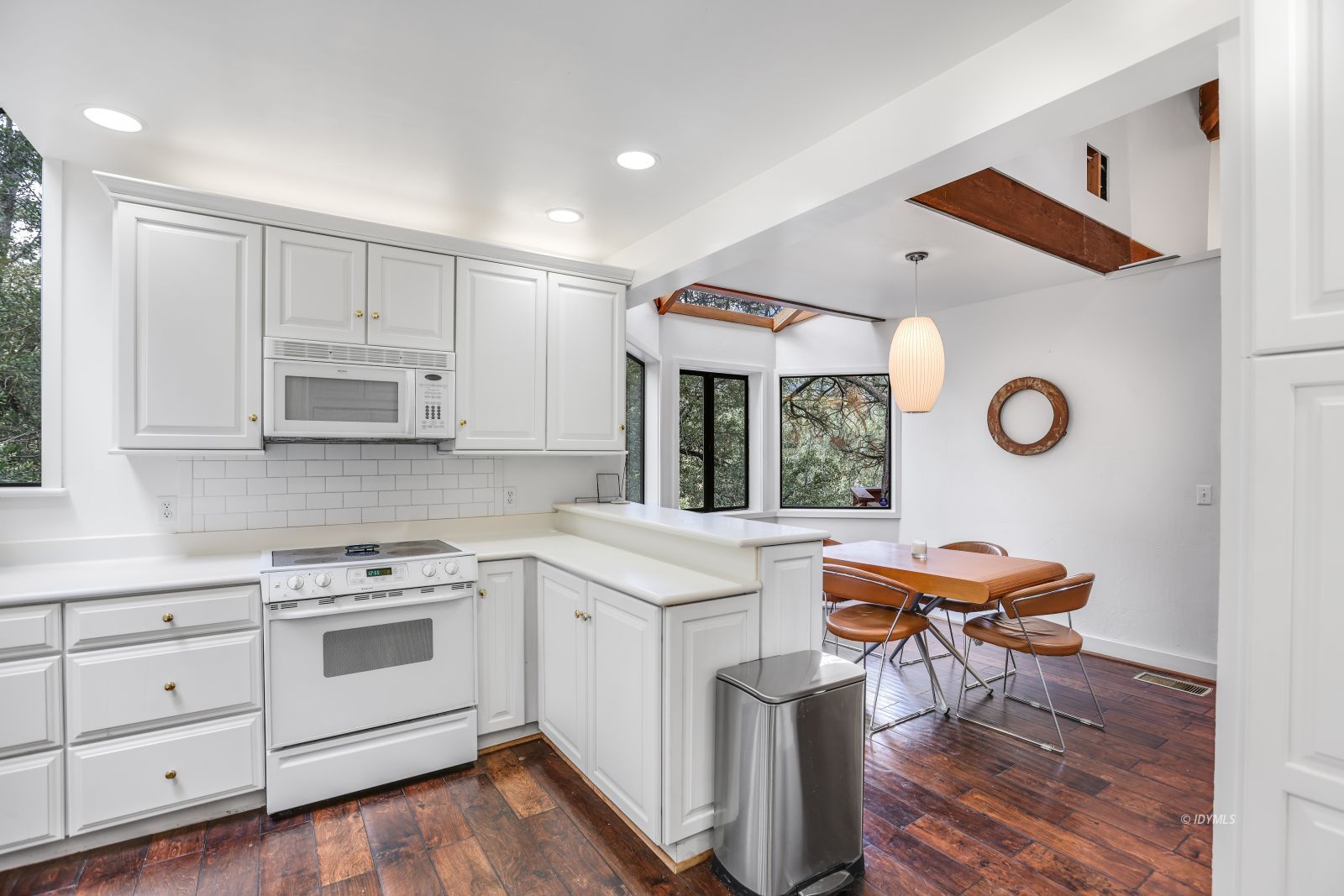 55100 Pine Crest Avenue Idyllwild, CA 92549 - Photo 16 of 50 a kitchen with stainless steel appliances granite countertop a stove a sink dishwasher and white cabinets with wooden floor