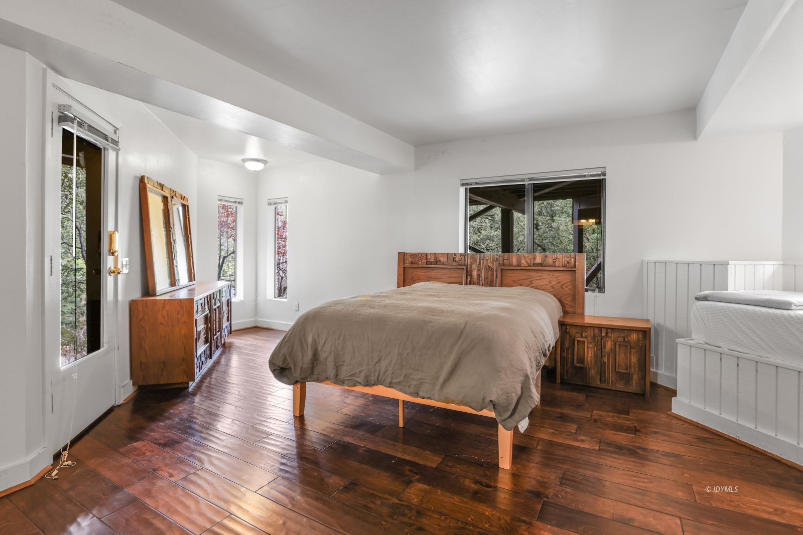 55100 Pine Crest Avenue Idyllwild, CA 92549 - Photo 35 of 50 a bedroom with a large bed a couch and two windows