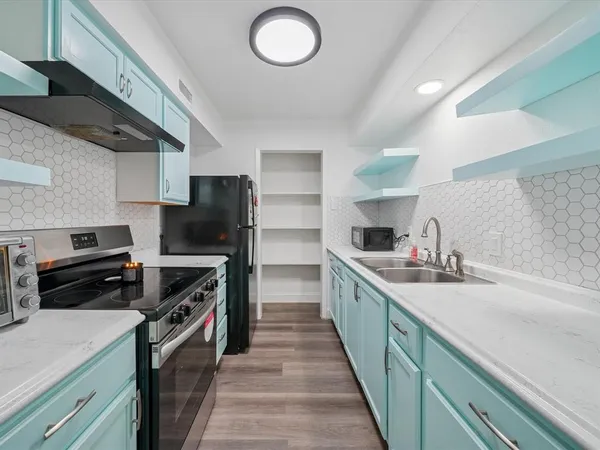 a kitchen with a stove sink and a refrigerator
