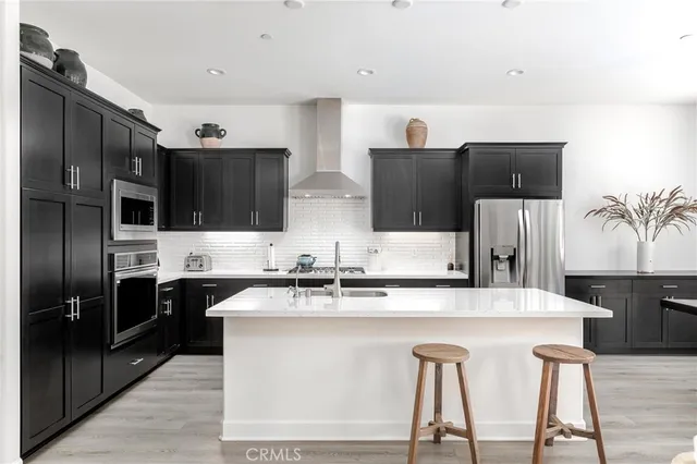 a kitchen with stainless steel appliances granite countertop a refrigerator and a stove top oven