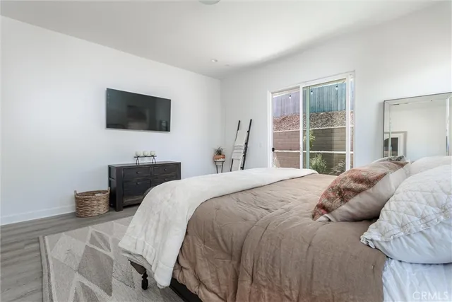 a bedroom with a bed a television and a window