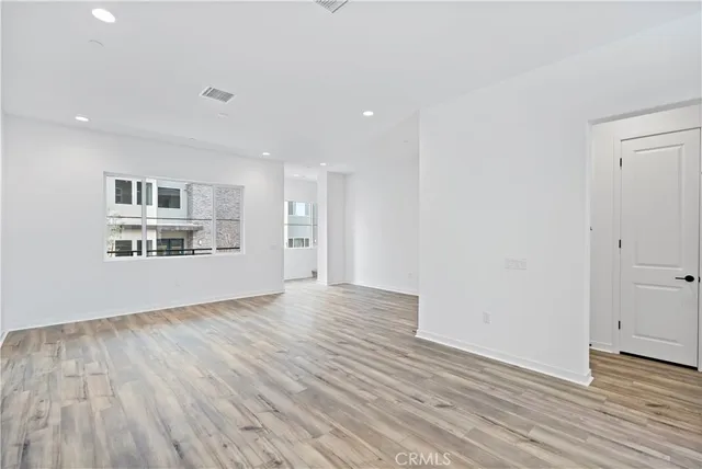 a view of a kitchen with wooden floor and a window