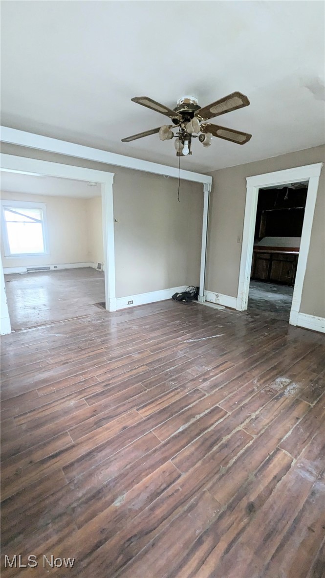 445 Cleveland Road Cleveland, OH 44108 - Photo 7 of 10 Unfurnished living room featuring dark wood-type flooring, a ceiling fan, and a baseboard radiator